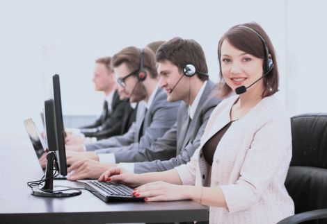 Servizi di segreteria, assistenza clienti e domiciliazione per aziende negli USA - L'immagine mostra un team di operatori di call center in abbigliamento professionale, seduti davanti ai computer e dotati di cuffie con microfono. In primo piano, una donna sorridente rappresenta il supporto amministrativo e il customer service. Us Company Advisor offre servizi di domiciliazione aziendale, segreteria virtuale e gestione clienti per le imprese italiane che desiderano stabilire una presenza professionale negli Stati Uniti.