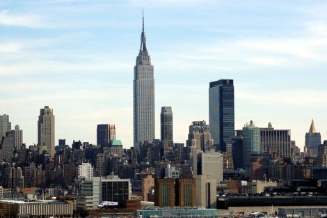 Skyline di New York con l'Empire State Building al centro, circondato da grattacieli e edifici iconici. Vista urbana chiara con cielo sereno, rappresentando il cuore finanziario e imprenditoriale degli Stati Uniti.